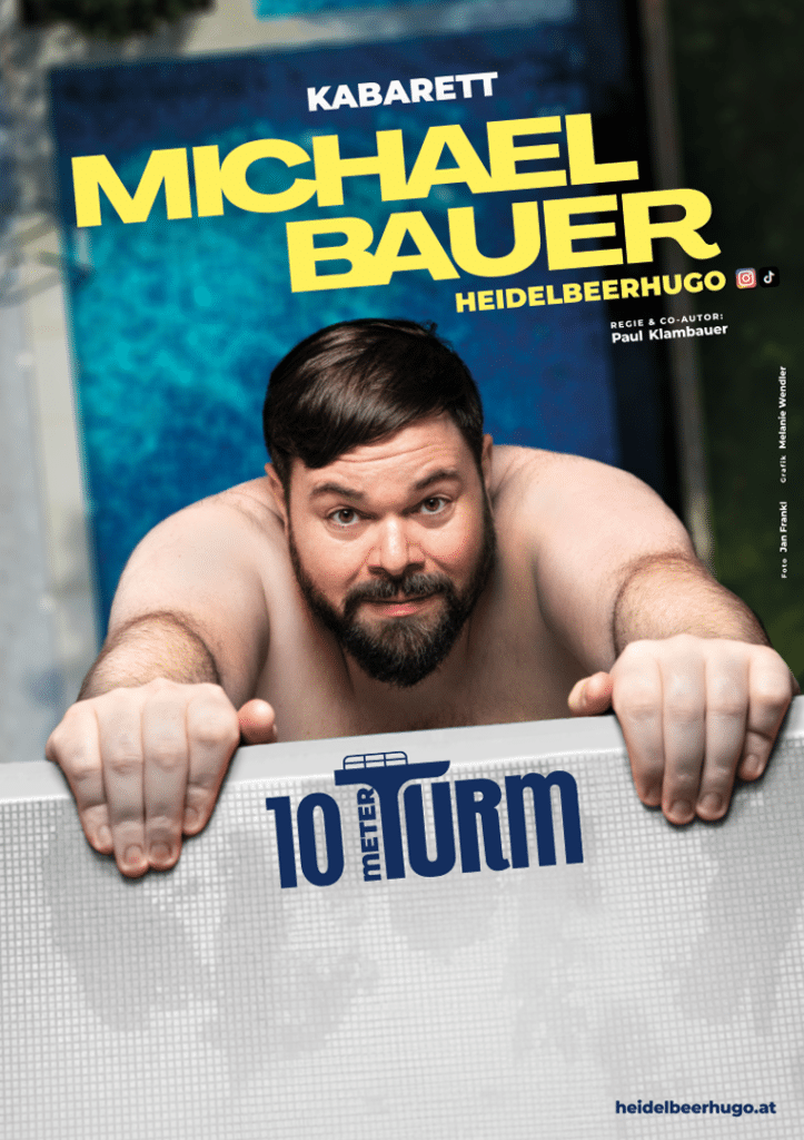 Kabarettist Michael Bauer (Heidelbeerhugo) hängt besorgt mit den Armen an einem 10-Meter-Sprungturm über einem Pool.